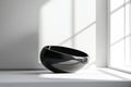 smooth circular form in black, with subtle light reflections that enhance its curves, placed on a