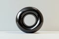 smooth circular form in black, with subtle light reflections that enhance its curves, placed on a