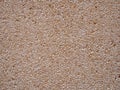 Smooth crushed granite pebble textured wall or floor surface background in shades of yellow brown and white