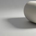 Smooth, cylindrical white object placed on a flat, neutral gray surface. The object is Royalty Free Stock Photo