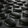Smooth, dark stones are artistically arranged on a flat surface. The stones, oval and Royalty Free Stock Photo