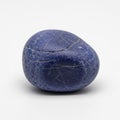 Smooth Deep Blue Pebble with Fine Cracks on a Light Gray Background stone rock Royalty Free Stock Photo