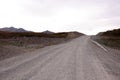 A smooth dirt road with a fence goes up the hill Royalty Free Stock Photo