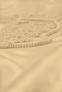 Smooth elegant golden silk or satin with pearls and lace as wedding background. In Sepia toned. Retro style Royalty Free Stock Photo