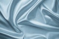 Smooth elegant silver silk fabric background. Metallic gray color of shiny textile, texture. Satin folds, waves pattern. Silky