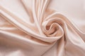 Smooth elegant wrinkled silk fabric background. Abstract crumpled satin texture. Cream color. Soft wavy pastel material, pink