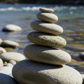 Smooth flat stones are stacked in a balanced cairn by a river Royalty Free Stock Photo