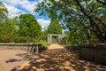 A smooth footpath in the garden with a stone entry way surrounded by lush green trees, grass and plants with gorgeous blue sky Royalty Free Stock Photo