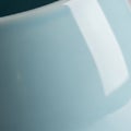 Smooth, glossy light blue surface, possibly a ceramic or glass object, with a curving Royalty Free Stock Photo