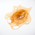Smooth, glossy substance creating an artistic splash on a white background in bright lighting