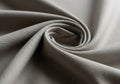 Smooth, grey fabric forms an elegant swirl pattern, showcasing its fine texture and so Royalty Free Stock Photo