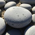 Smooth, grey pebbles with a matte texture, scattered on a sandy surface. The stones Royalty Free Stock Photo
