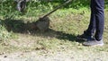 Smooth lawn outside. Man cleaning a public street with a manual lawn mower