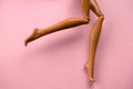 smooth legs of a plastic toy doll on a soft pink background Royalty Free Stock Photo