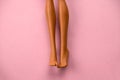 smooth legs of a plastic toy doll on a soft pink background Royalty Free Stock Photo