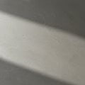 A smooth, light gray surface with subtle marbling. A diagonal shadow crosses the Royalty Free Stock Photo