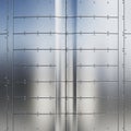 Smooth metallic surface composed of riveted steel panels. The panels exhibit a Royalty Free Stock Photo