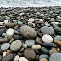 Smooth multicolored pebbles cover a beach with an array of greys Royalty Free Stock Photo