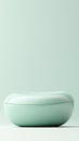 Smooth oval object rests on a flat surface. Light green pastel tones. Curved shapes showcase simple elegance against a clean Royalty Free Stock Photo