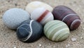 Smooth pebbles with striking colors and patterns rest on sandy ground Royalty Free Stock Photo