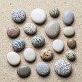 Smooth pebbles of varying sizes and colors are arranged on a sandy Royalty Free Stock Photo