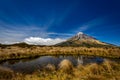 A smooth pond with reflection of snow capped peak of Taranaki