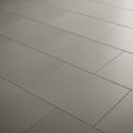 Smooth, rectangular floor tiles in a light gray color are arranged in an offset pattern. The tiles Royalty Free Stock Photo