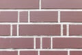 Smooth red decorative brick wall with white cement grout between them. Brick fence background texture Royalty Free Stock Photo