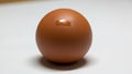 A smooth, reddish-brown sphere is displayed against a light backgroun Royalty Free Stock Photo