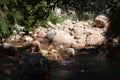Smooth rocks in a riverbed with a stream of calming waters. Royalty Free Stock Photo