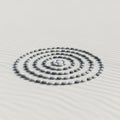Smooth, round gray stones are arranged in a precise spiral pattern on a raked sandy surface. The Royalty Free Stock Photo