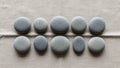 Smooth round stones arranged in two rows on a textured beige fabric Royalty Free Stock Photo