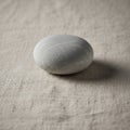 Smooth, rounded gray stone resting on Royalty Free Stock Photo