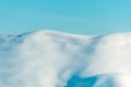 Smooth snow-covered hills against clear blue winter sky Royalty Free Stock Photo