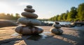 Smooth stones are balanced in two separate stacks on a flat rock surface near a river. The stones Royalty Free Stock Photo