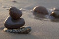 Smooth stones lie on wet sand by the sea Royalty Free Stock Photo