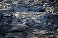 Smooth, undulating surface of frozen pahoehoe lava. Frozen lava wrinkled in tapestry-like folds and rolls resembling twisted rope