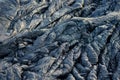 Smooth, undulating surface of frozen pahoehoe lava. Frozen lava wrinkled in tapestry-like folds and rolls resembling twisted rope Royalty Free Stock Photo