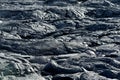 Smooth, undulating surface of frozen pahoehoe lava. Frozen lava wrinkled in tapestry-like folds and rolls resembling twisted rope