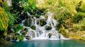 Smooth water effect capturing motion of clean mountain waterfall in forest Royalty Free Stock Photo