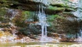 Smooth waterfall on a rock full of moss