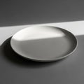 A smooth white ceramic plate sits Royalty Free Stock Photo