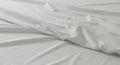 Smooth white fabric with visible creases is laid out on a flat surface, creating a Royalty Free Stock Photo