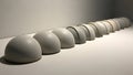 Smooth white hemispherical objects arranged in a straight line Royalty Free Stock Photo