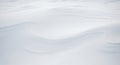Smooth, windswept snow forms gentle curves and subtle ridges, creating a minimalist landscape. The Royalty Free Stock Photo
