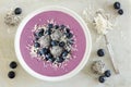 Smoothie bowl with blueberries, dragon fruit, coconut, over marble Royalty Free Stock Photo