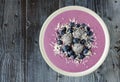 Smoothie bowl with blueberries, dragon fruit, coconut, on rustic wood Royalty Free Stock Photo