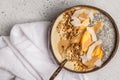 Smoothie bowl with chia pudding, peach, coconut and granola in a