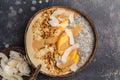 Smoothie bowl with chia pudding, peach, coconut and granola in a