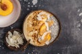 Smoothie bowl with chia pudding, peach, coconut and granola in a